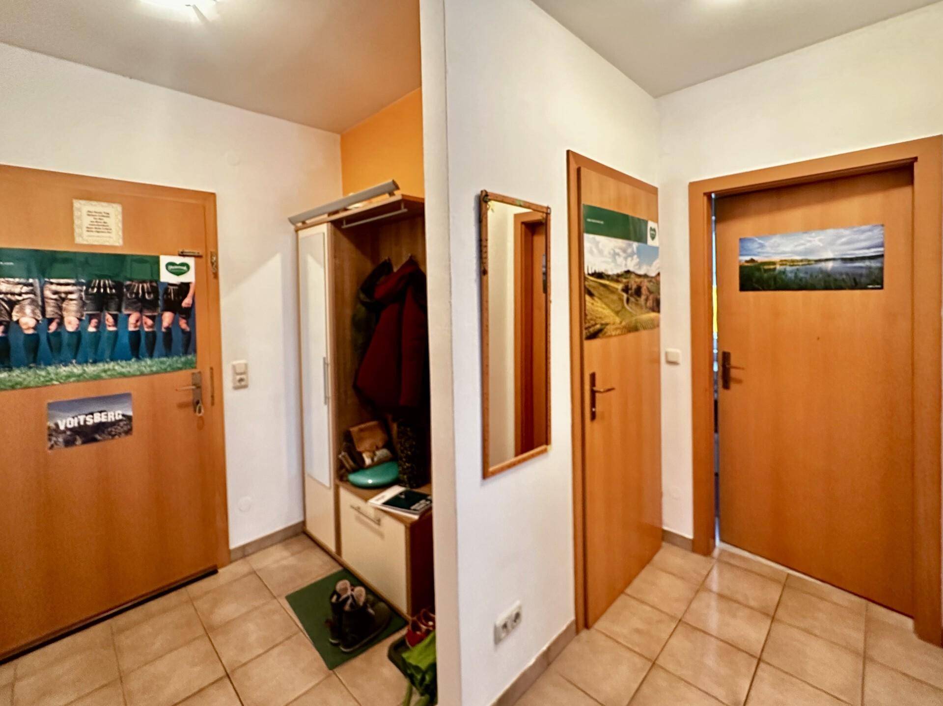 Eingangsbereich mit Fliesenboden, Garderobe und mehreren Türen.