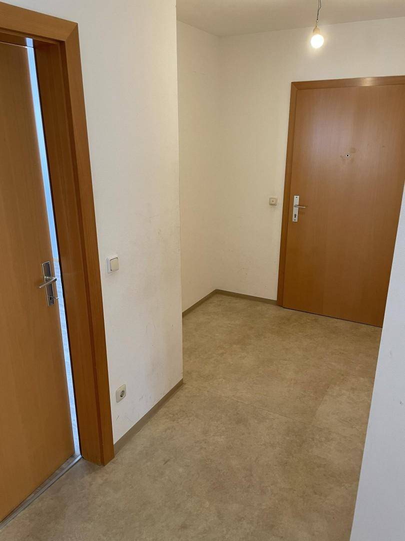 Heller Flur mit Laminatboden und Holztüren, verbindet die verschiedenen Räume der Wohnung.