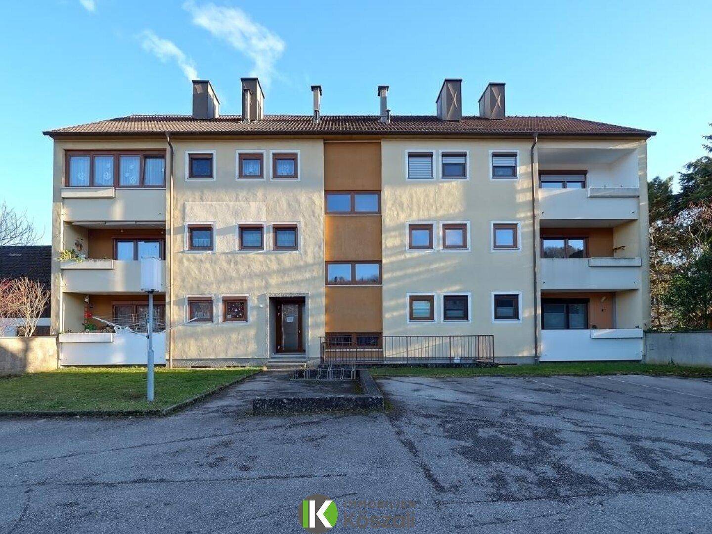 Ansicht der modernen Fassade eines Mehrfamilienhauses mit mehreren Etagen und Balkonen.