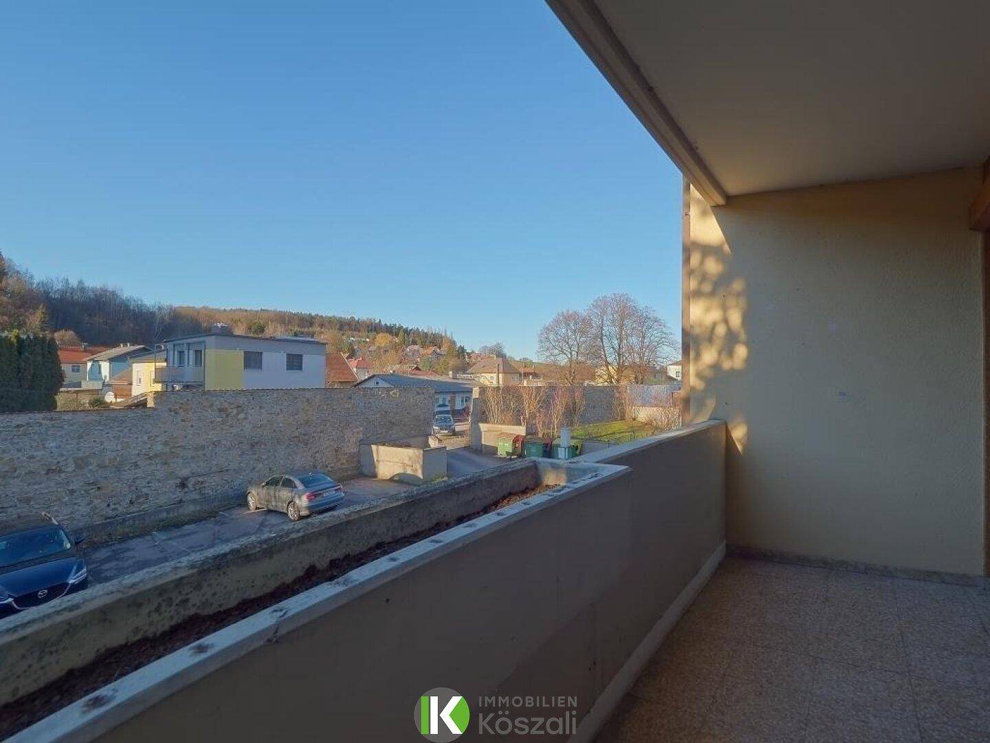 Balkon mit weitem Blick über die Straße und die umliegende grüne Landschaft.