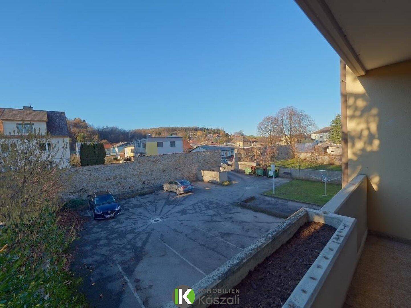 Balkon mit Blick auf den Parkplatz und den gemeinschaftlich genutzten Gartenbereich.