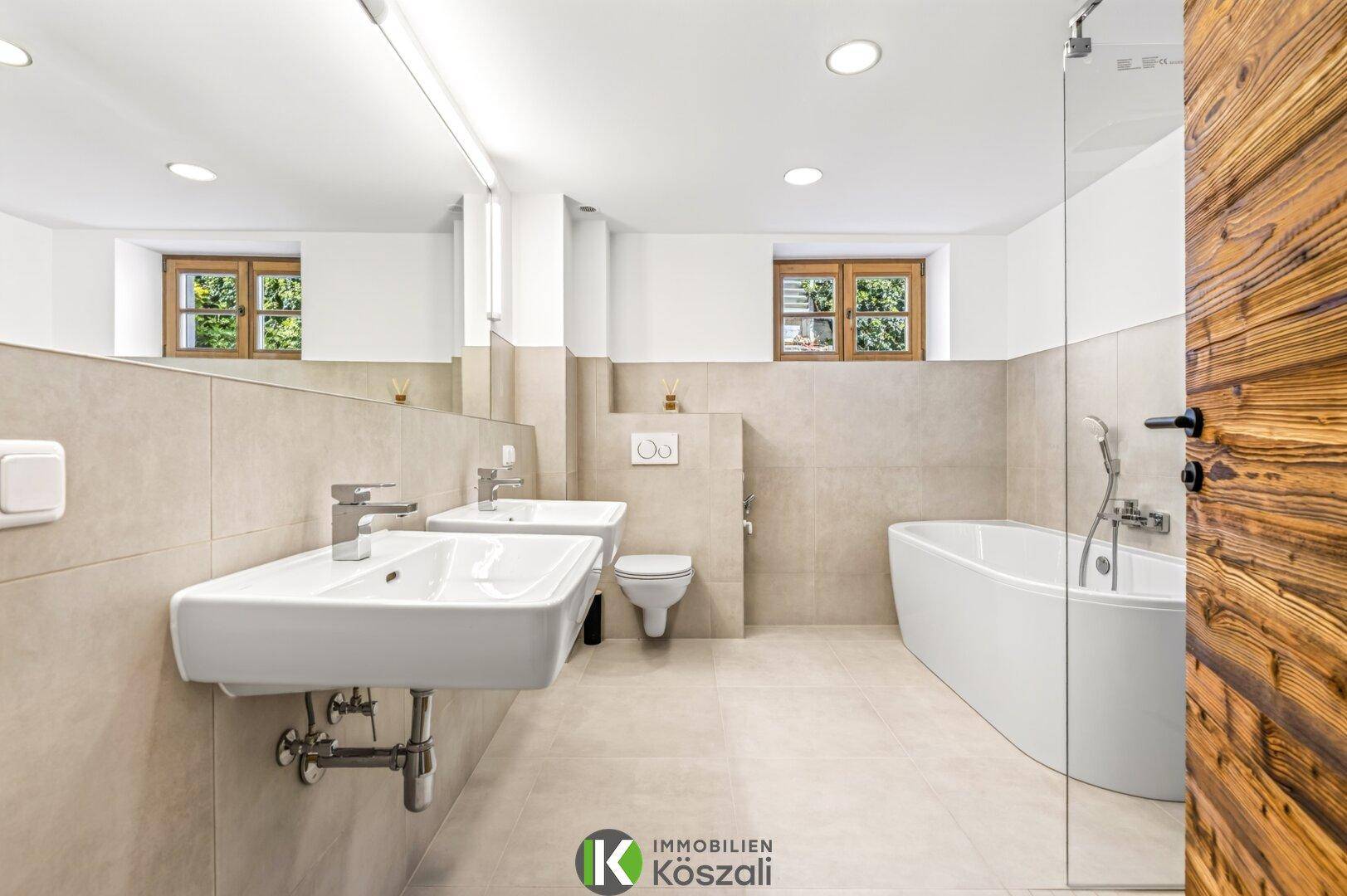 Modernes Badezimmer mit Doppelwaschbecken, Badewanne und separater Dusche.