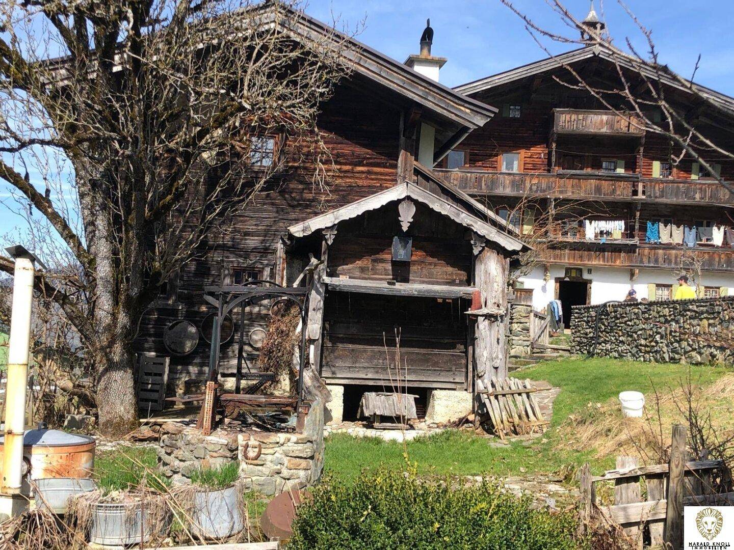 Altes Holzhaus mit traditioneller Architektur und rustikalen Elementen in ländlicher Umgebung.