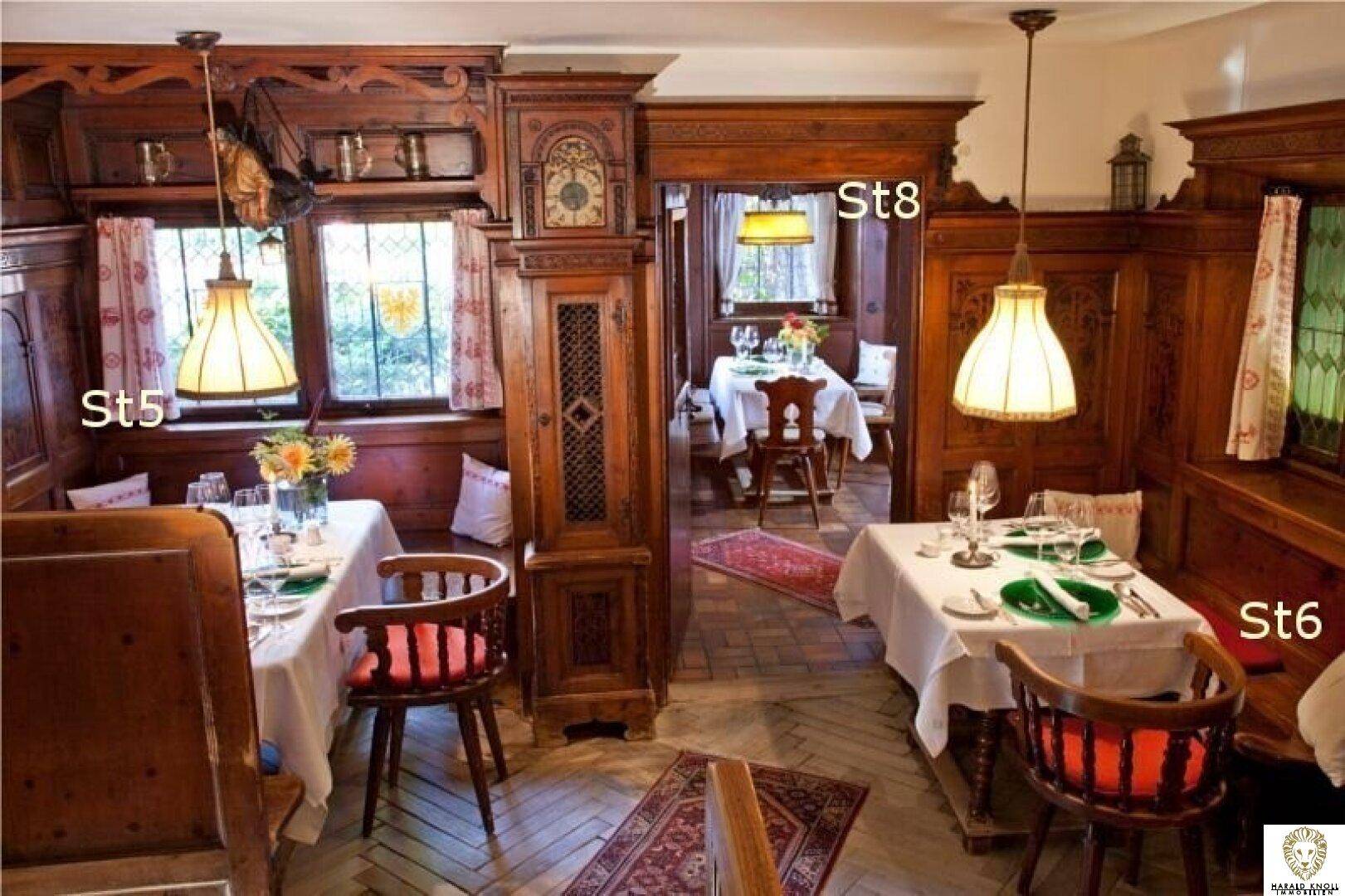 Traditioneller Essbereich mit dunklen Holzvertäfelungen, Pendelleuchten und Blick auf den Garten.