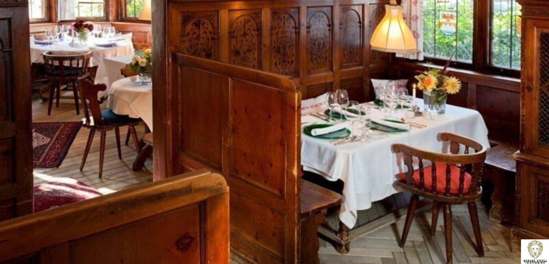 Gemütlicher Essbereich mit Holztischen und -bänken, traditioneller Einrichtung und Blick nach draußen.