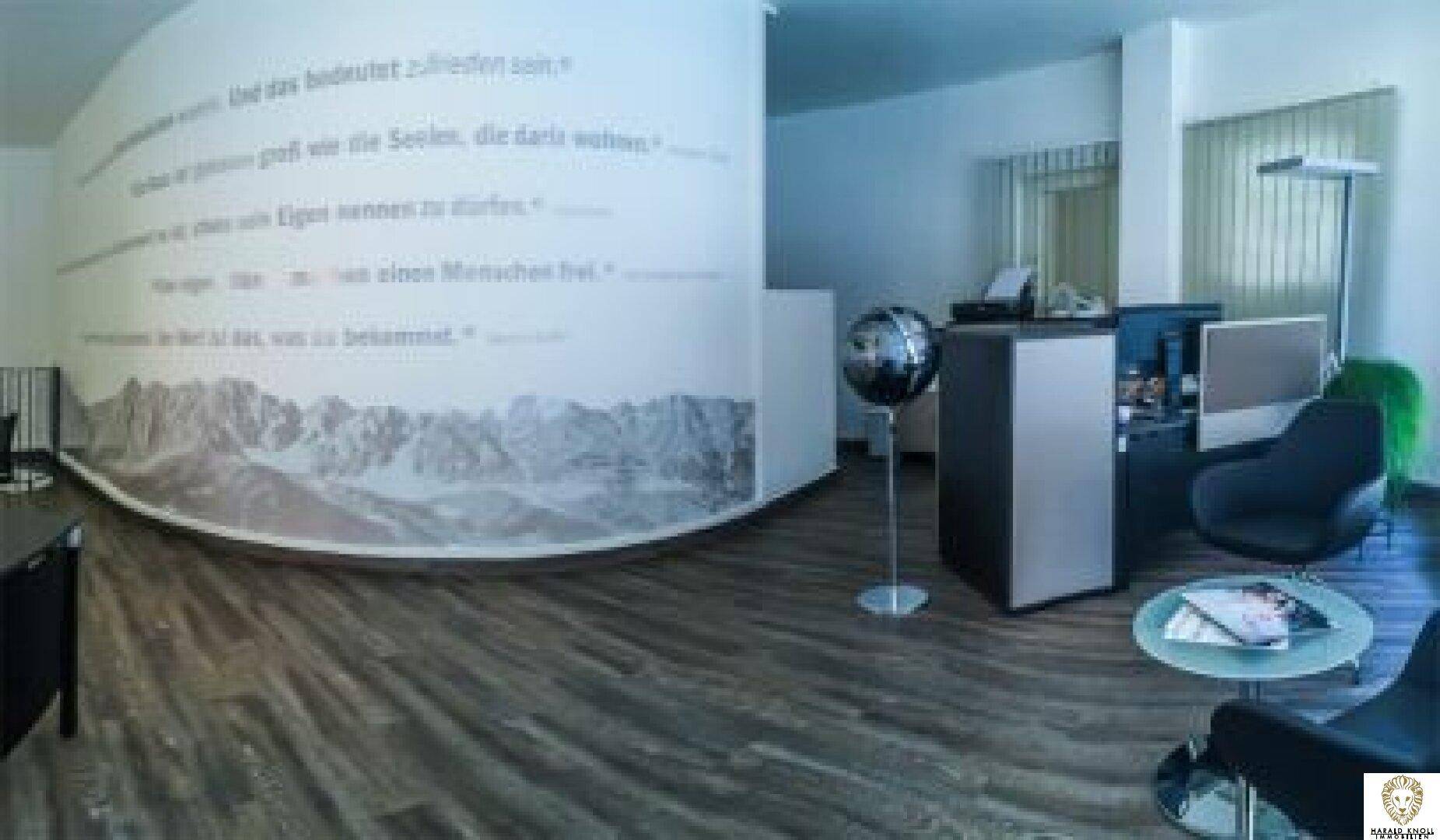 Geräumiges Büro mit geschwungener Wanddekoration, Sitzgelegenheiten und dunklem Holzboden, hell und modern gestaltet.