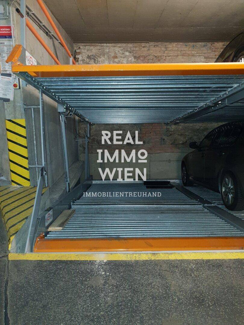Detailansicht eines modernen Parkliftsystems in der Tiefgarage, mit einem geparkten Fahrzeug auf der unteren Ebene.