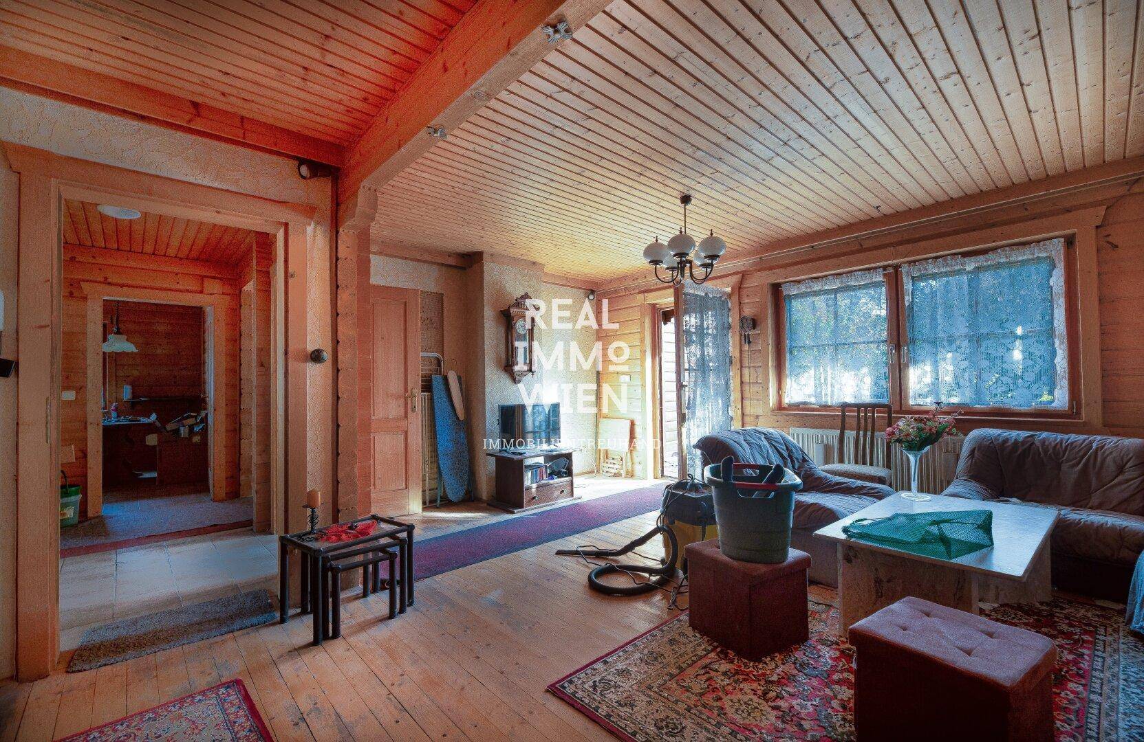 Rustikales Wohnzimmer mit Holzwänden, Holzboden und traditioneller Einrichtung.