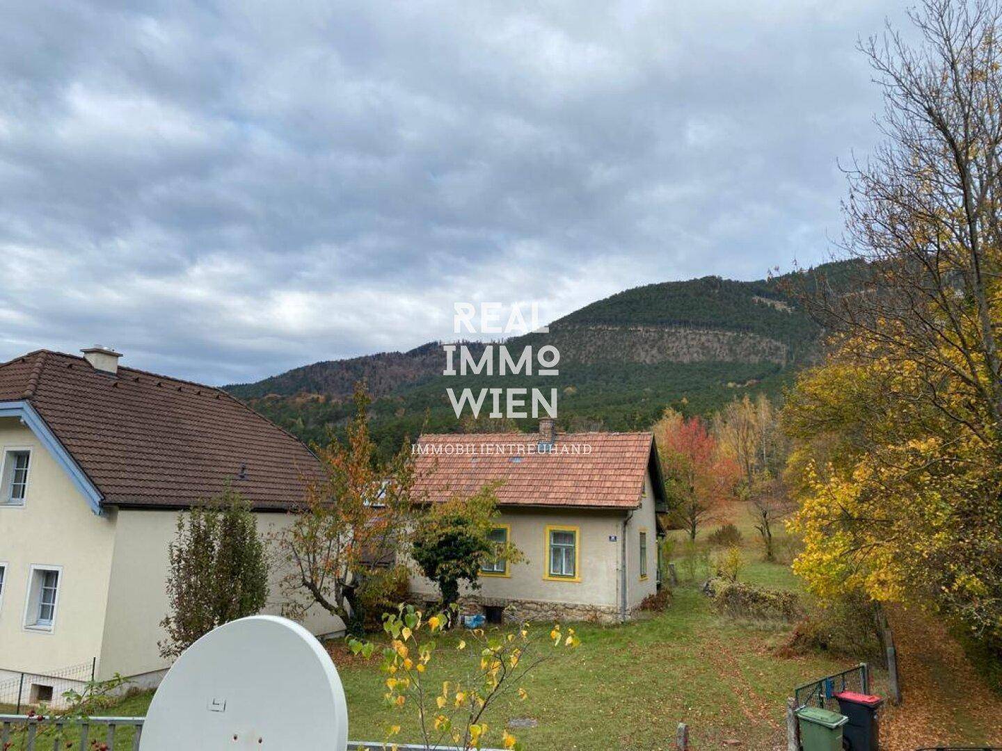 Weitläufiger Blick auf die ländliche Umgebung mit Bergen und herbstlicher Vegetation.