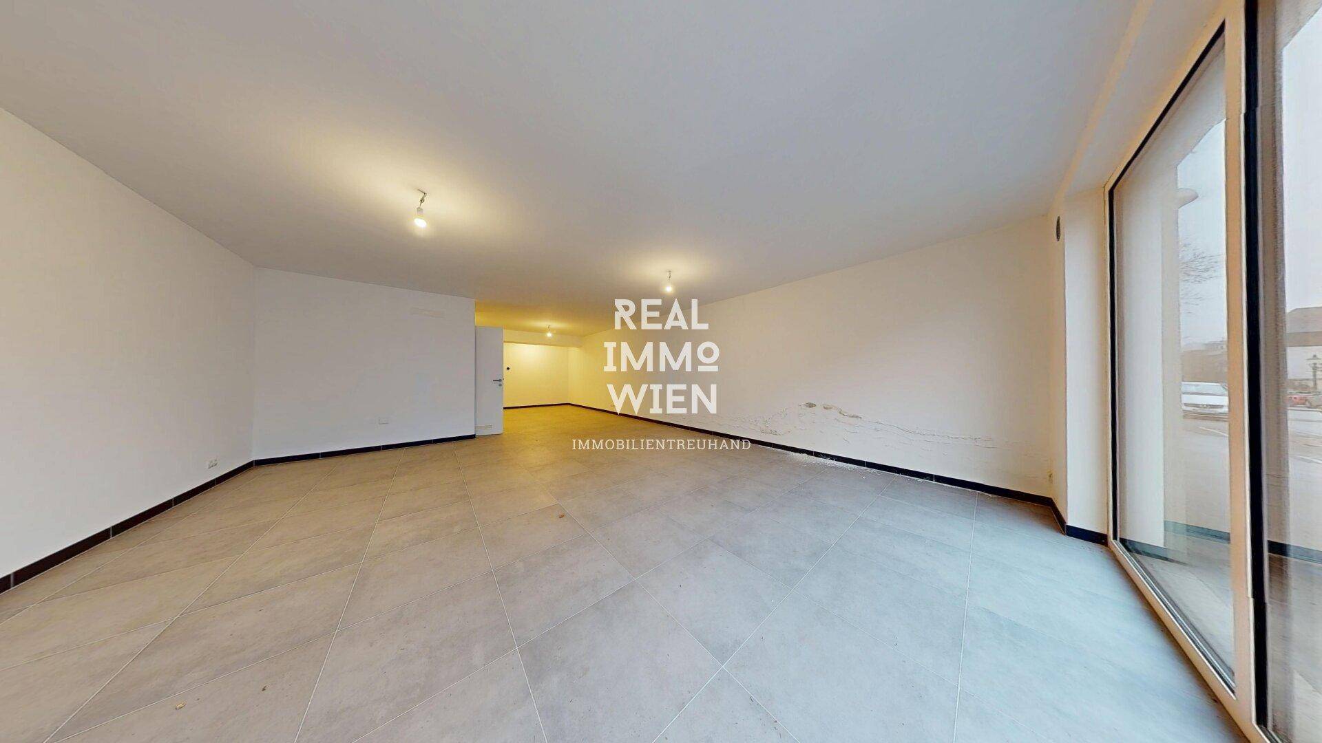Geräumiger, heller Innenraum mit großen Fensterfronten und modernem Fliesenboden, ideal für Geschäftsnutzung.