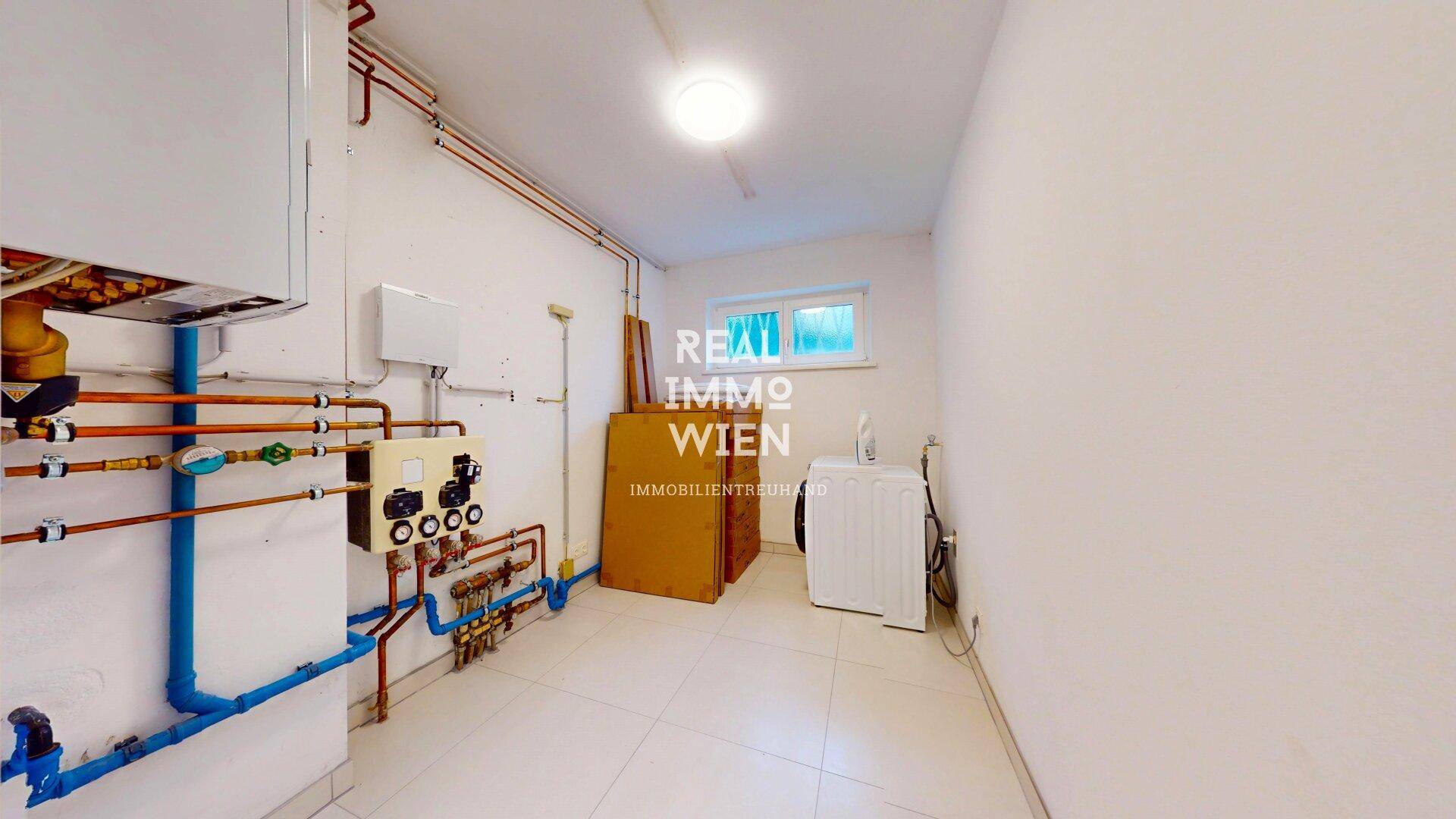 Funktionaler Hauswirtschaftsraum mit Heizungsanlage, Leitungen und Waschmaschine.