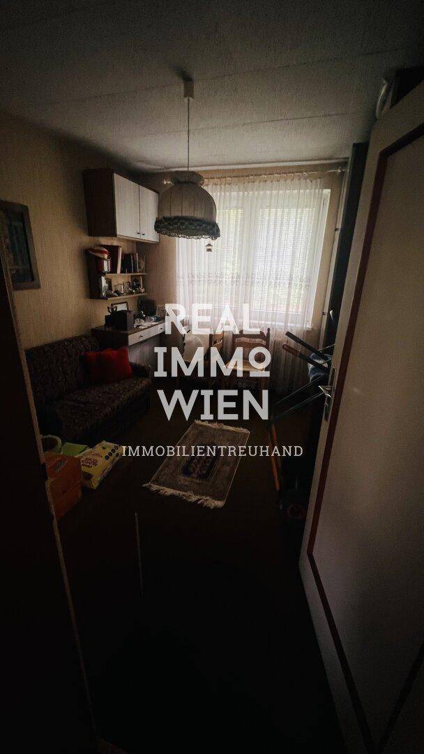 Kleiner, funktionaler Raum mit Schreibtisch, Regalen und Fenster, ideal als Arbeits- oder Gästezimmer.