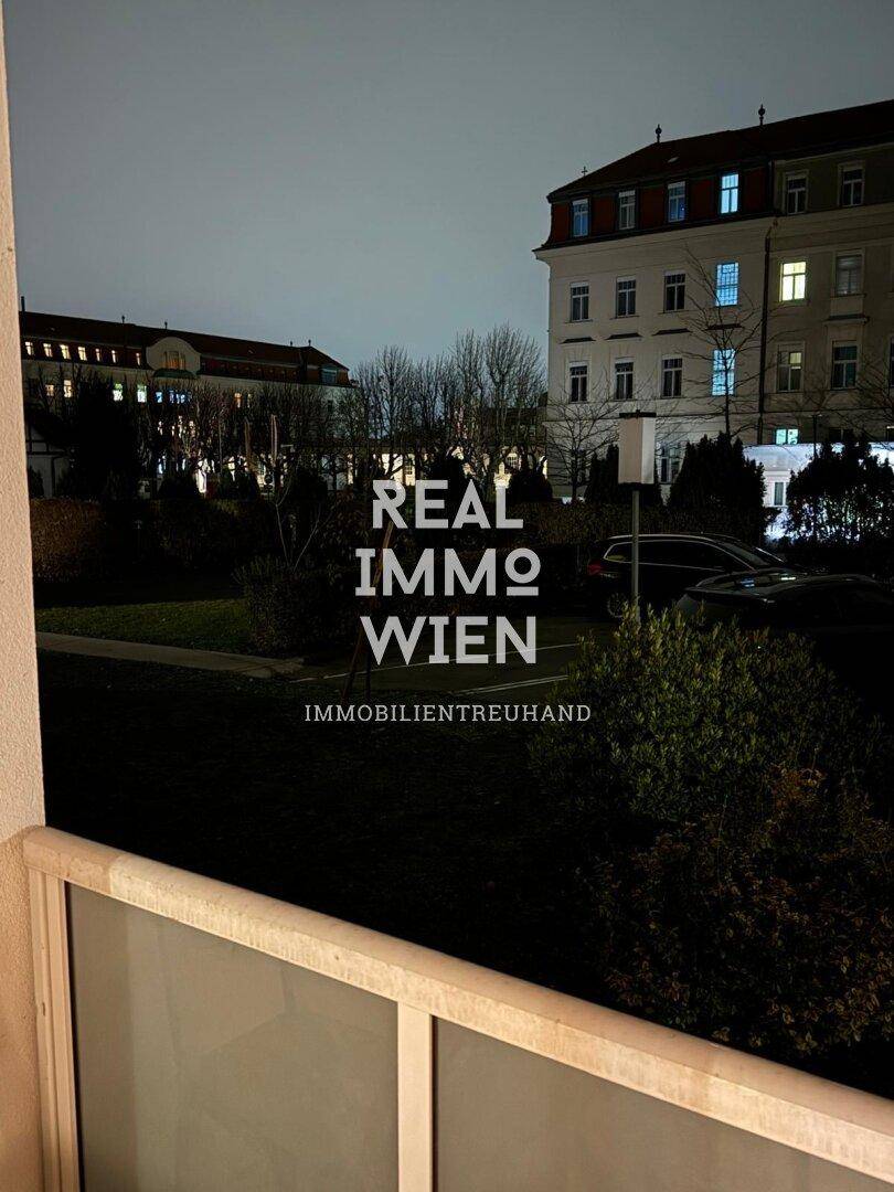 Abendlicher Blick vom Balkon auf die umliegenden Gebäude und Grünflächen.