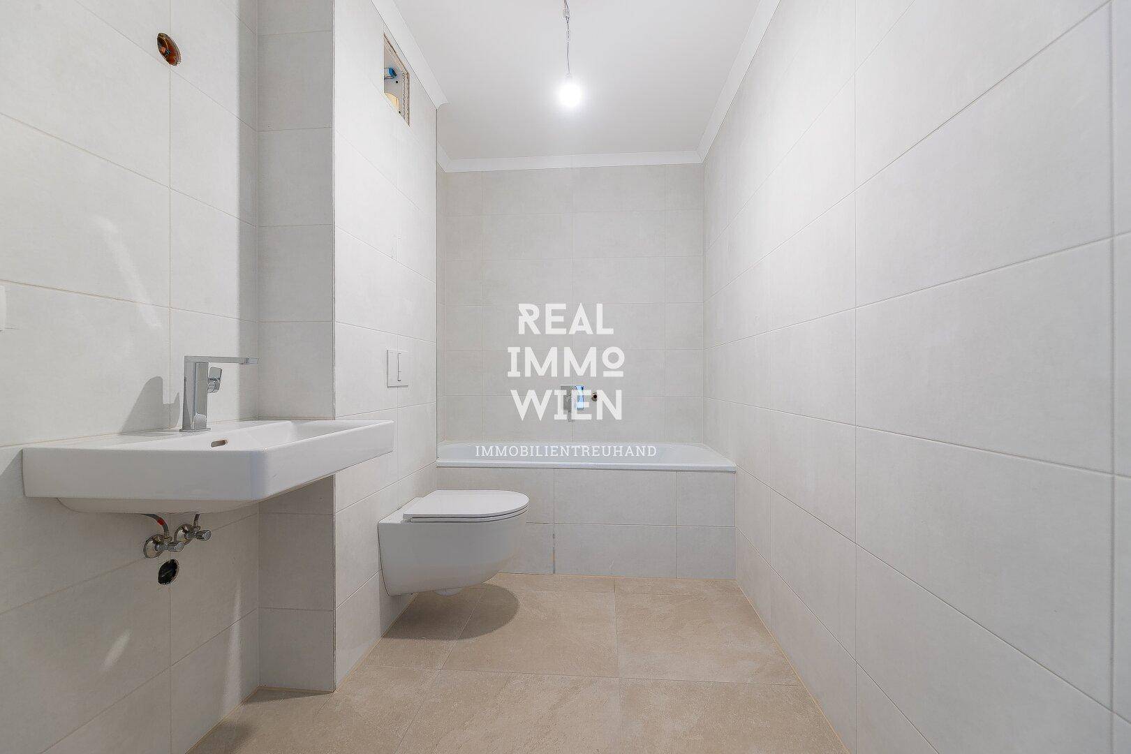 Modernes Badezimmer mit Badewanne, wandhängendem WC und hellen Fliesen.