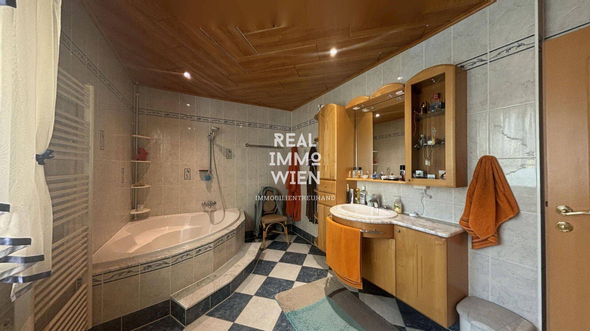 Badezimmer mit Eckbadewanne, Dusche, Holzwaschtisch und beheiztem Handtuchhalter.