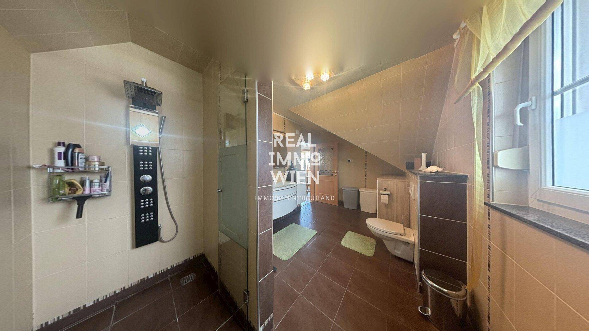 Modernes Badezimmer im Dachgeschoss mit Duschkabine und Dachschräge.