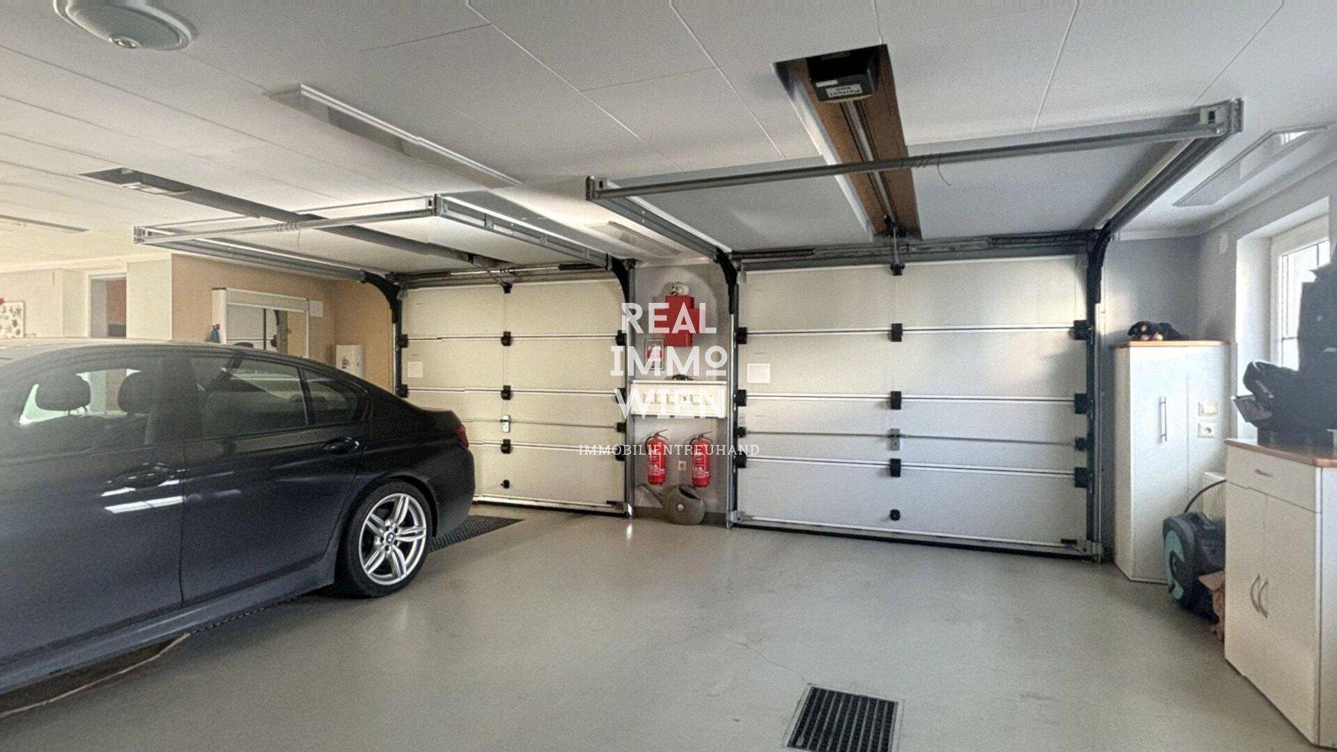 Geräumige Doppelgarage mit zwei Sektionaltoren und Platz für Fahrzeuge.