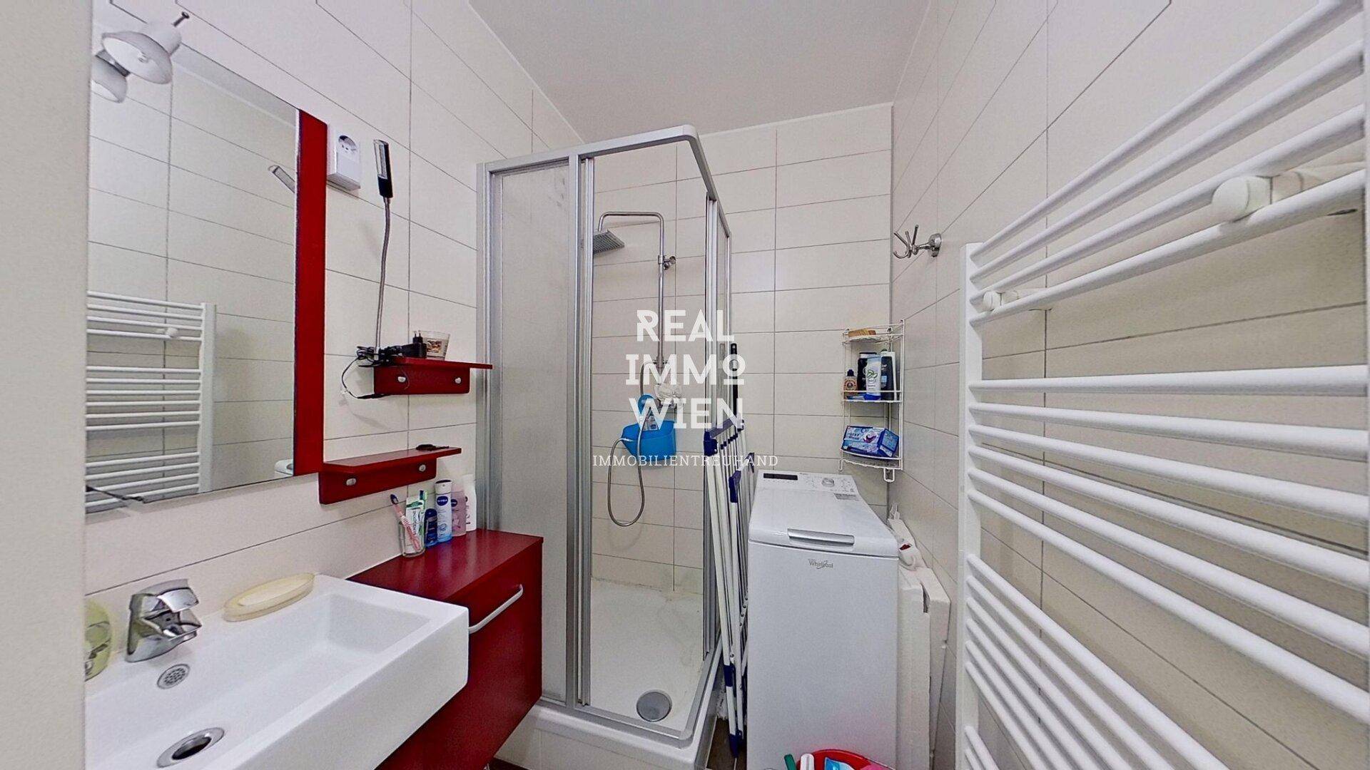 Modernes Badezimmer mit Duschkabine, Waschbecken, Spiegel und Handtuchheizkörper.