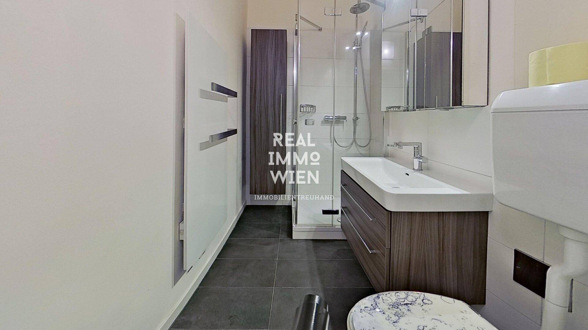 Modernes Badezimmer mit ebenerdiger Dusche, Waschtisch und beheiztem Handtuchhalter.