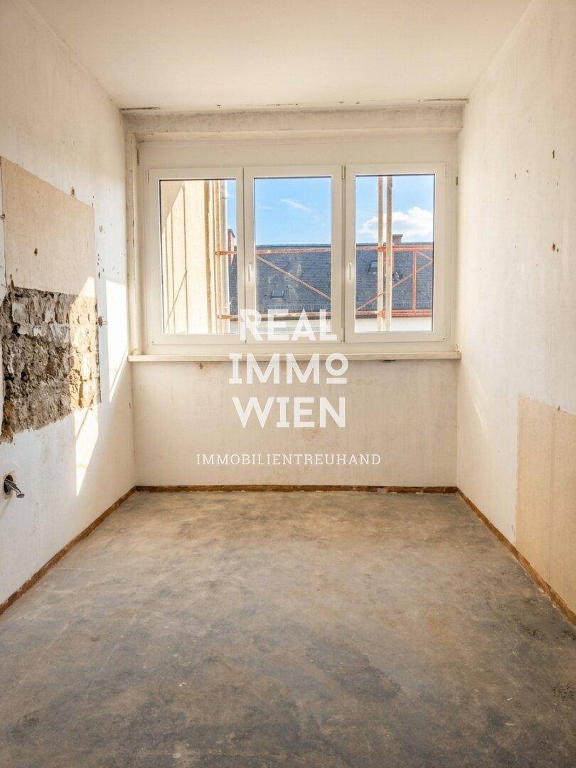 Kleiner Raum mit Betonboden und Fenster, ideal als Abstellraum oder zukünftiges Büro.