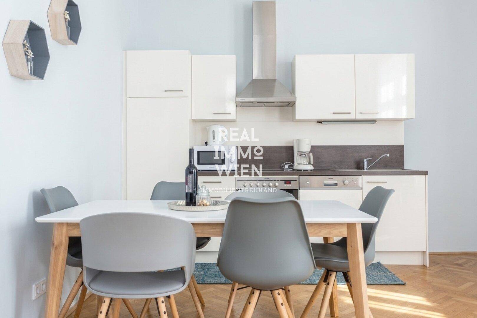 Moderne Einbauküche mit weißen Schränken, Essbereich und Geräten, ideal für gemeinsame Mahlzeiten.