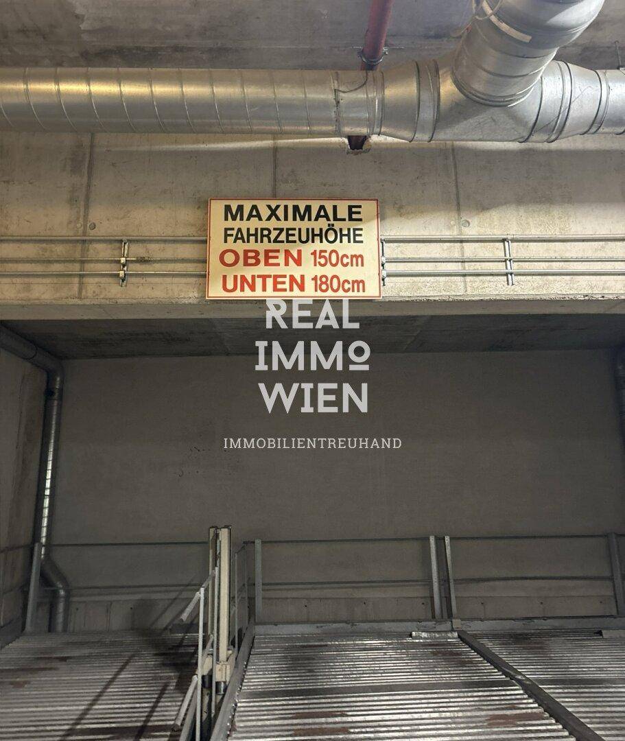 Eine Tiefgarage mit Betondecken und -wänden, sichtbaren Lüftungsrohren und einem Schild zur maximalen Fahrzeughöhe.
