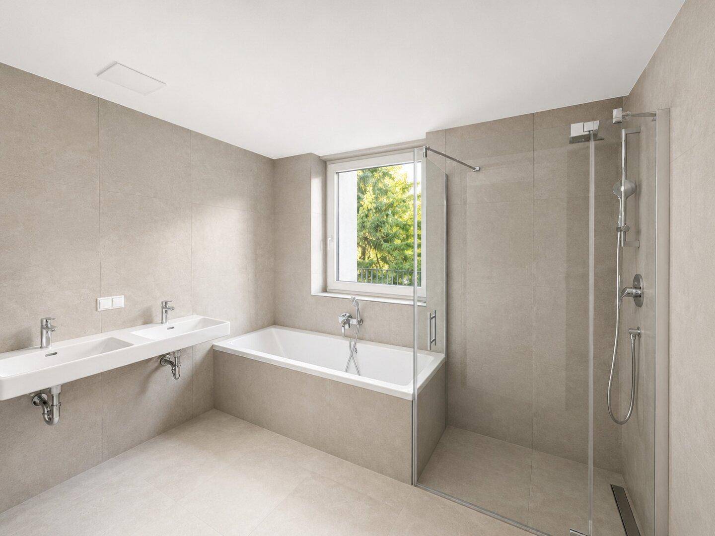 Modernes Badezimmer mit großen beigefarbenen Fliesen, Doppelwaschbecken, Badewanne und Dusche.