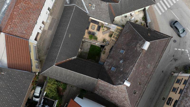 Übersichtliche Luftaufnahme des Innenhofs mit großer Terrasse und den umliegenden Gebäudedächern.