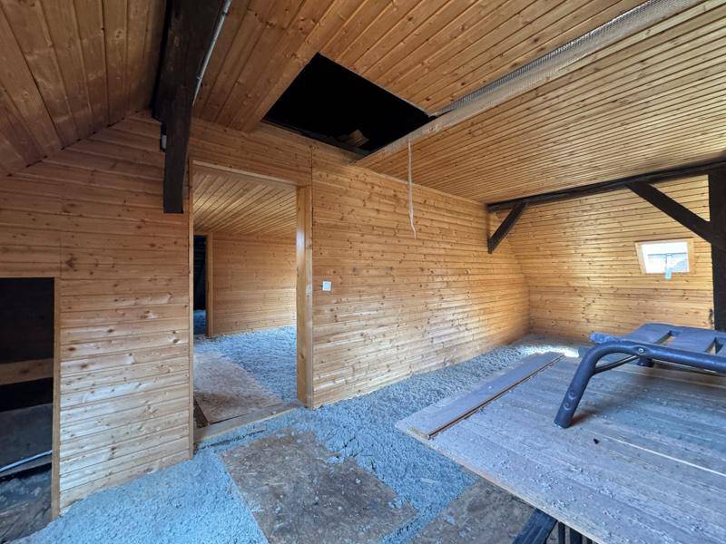 Dachboden mit Holzverkleidung und sichtbaren Balken, bereit für den Ausbau und die Renovierung.