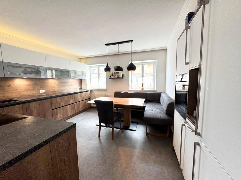 Geräumige moderne Küche mit Essbereich, viel Tageslicht und stilvollen Holzfronten.