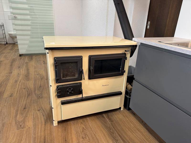 Nahaufnahme eines traditionellen Holzofens in der Küche, bereit zum Kochen und Heizen.