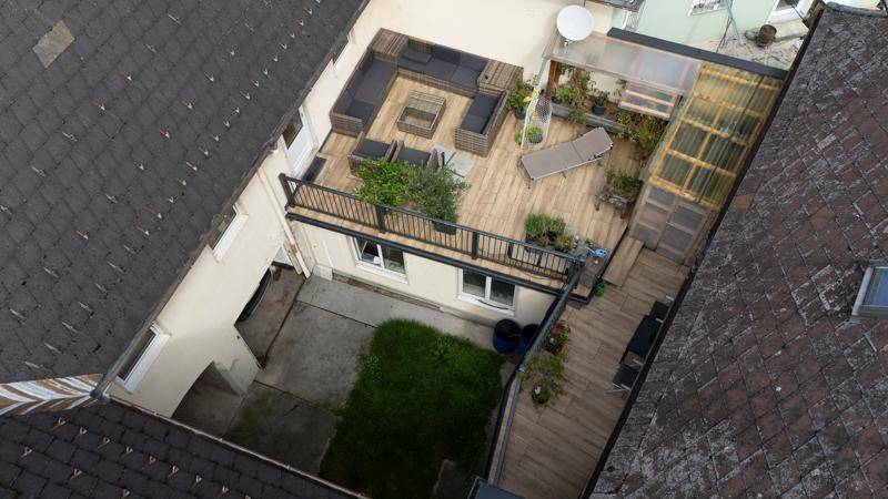 Luftaufnahme der Dachterrasse mit angrenzender kleiner Rasenfläche im geschützten Innenhof.