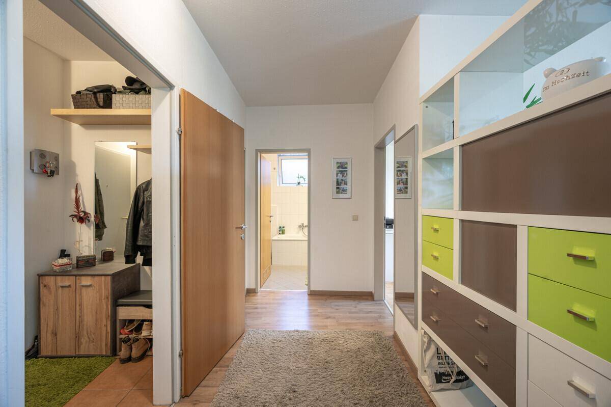 Heller Flur mit praktischen Einbauschränken und Blick ins Badezimmer.