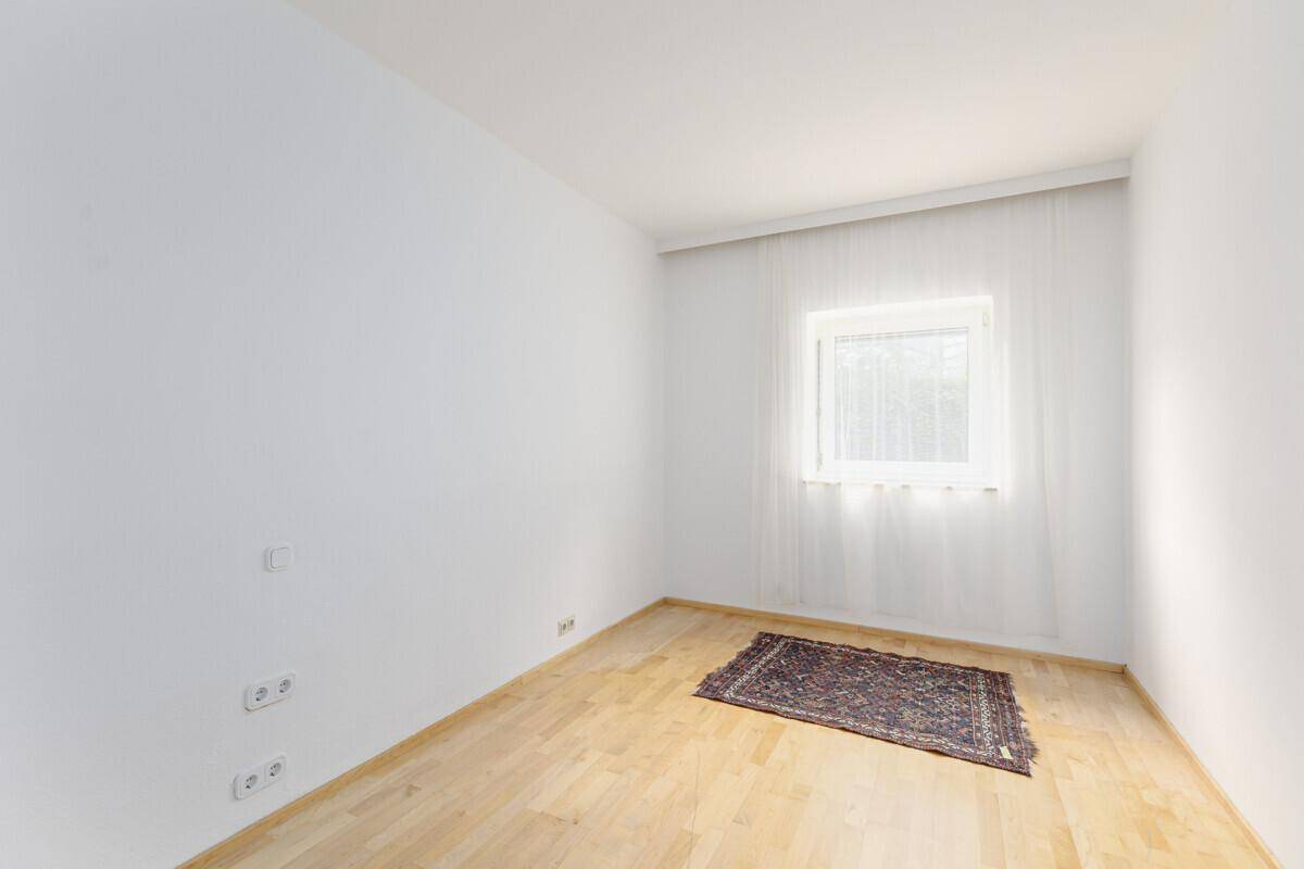 Kleines, helles Zimmer mit Parkettboden und einem Fenster, ideal als Schlaf- oder Arbeitszimmer.