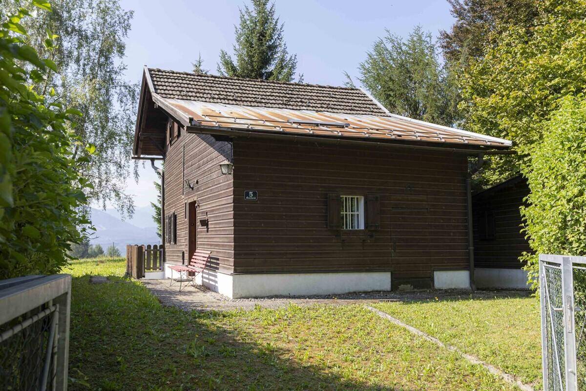 Rustikales Holzhaus mit Satteldach und gepflegtem Vorgarten in ländlicher Umgebung.