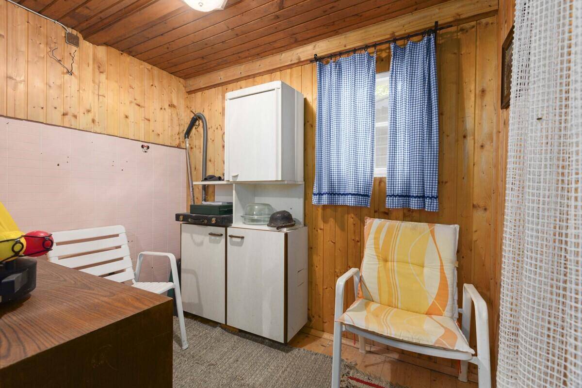 Praktischer Abstellraum mit Holzvertäfelung und einfachen Lagermöglichkeiten für Haushaltsgeräte.