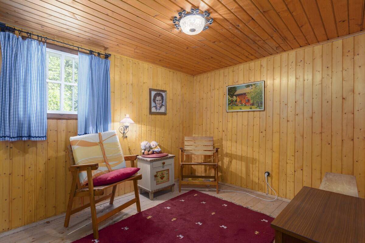 Helles Schlafzimmer mit Holzvertäfelung, Einzelbett und traditioneller Einrichtung.
