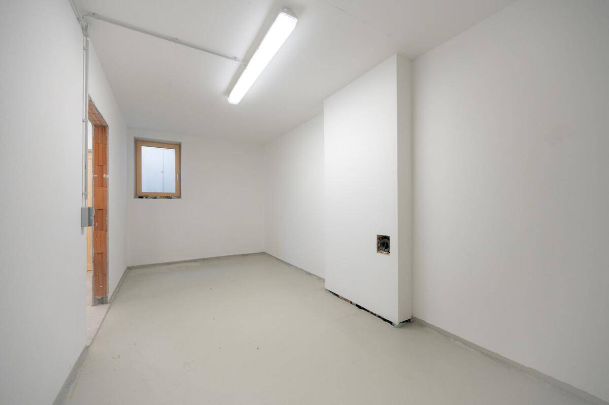Heller Abstellraum oder Kellerraum mit Fenster und einfachem Bodenbelag.