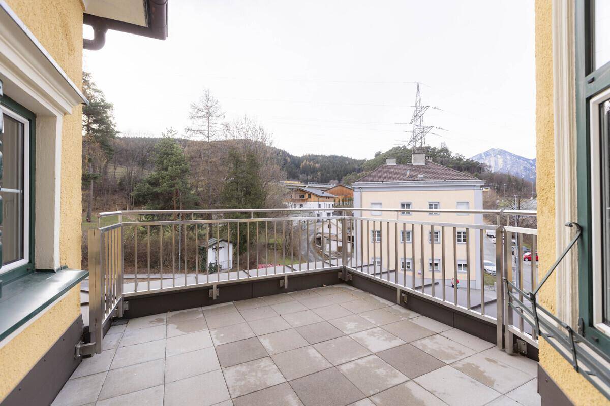 Großer Balkon mit Fliesenboden und Metallgeländer, bietet einen weiten Blick auf die Umgebung.