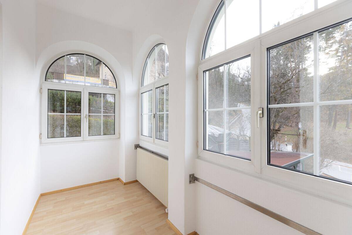 Heller Erkerbereich mit mehreren Rundbogenfenstern, die viel Tageslicht spenden.