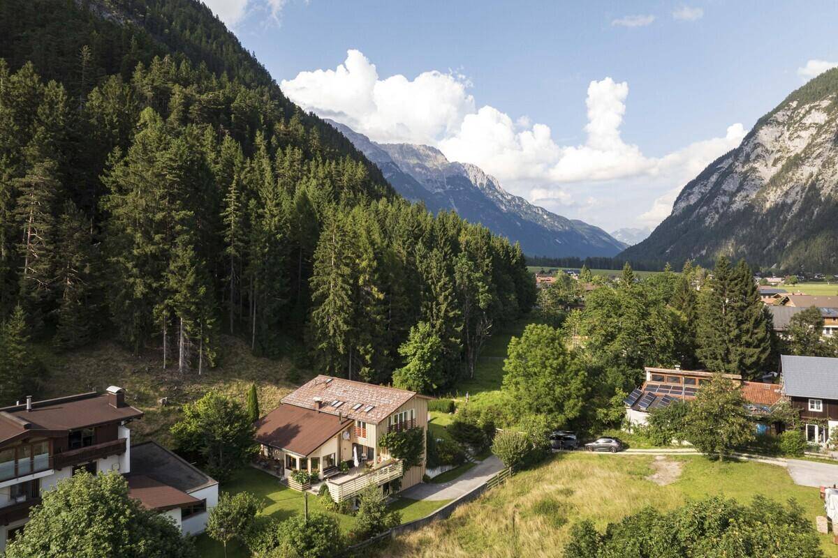 Weitläufige Luftaufnahme des Anwesens eingebettet in eine malerische Berglandschaft mit Wald.