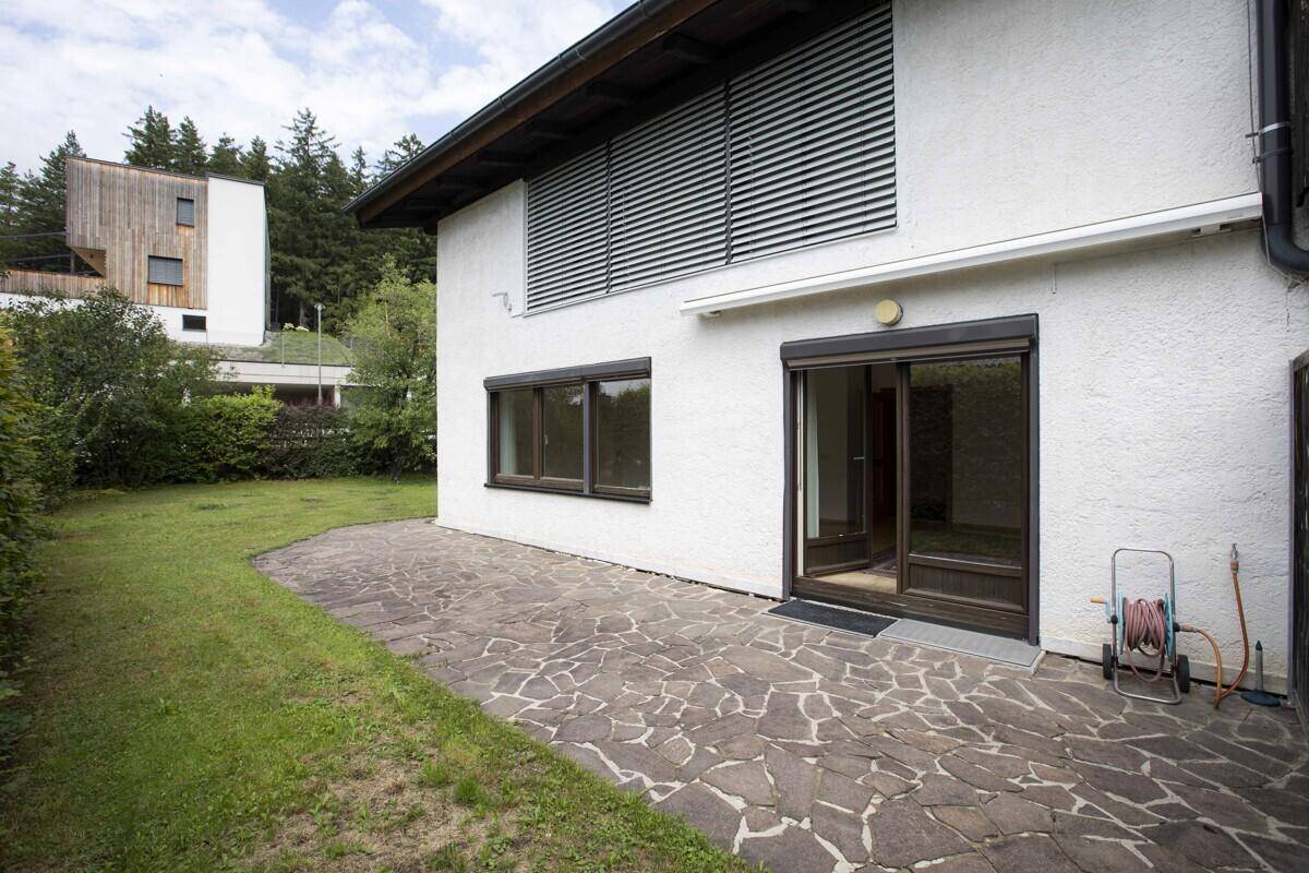 Terrasse mit Steinplatten und Rasenfläche, ideal für entspannte Stunden im Freien.