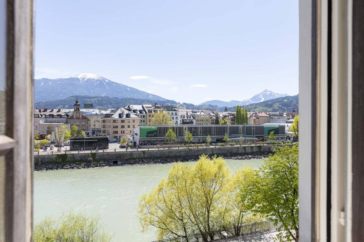 Panoramablick aus dem Fenster auf die Stadt, den Fluss und die umliegende Berglandschaft.