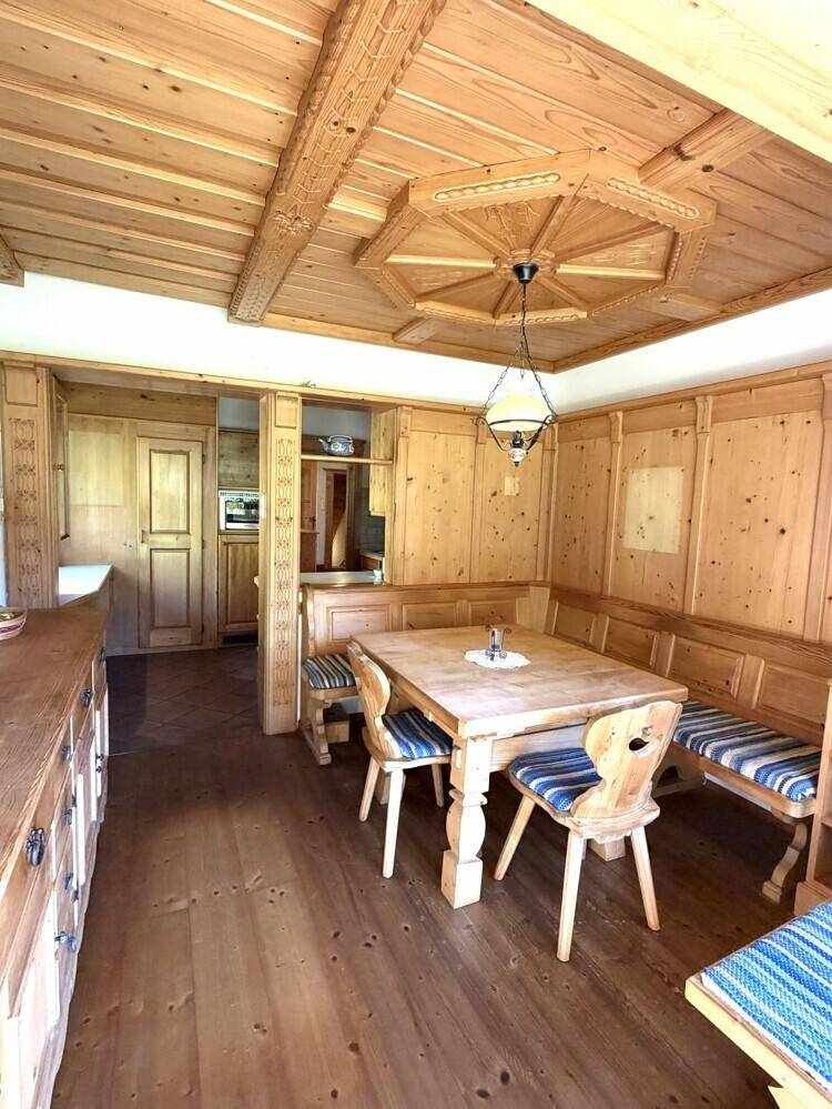 Traditionelle Wohnküche mit Holztäfelung, Eckbank und Esstisch.