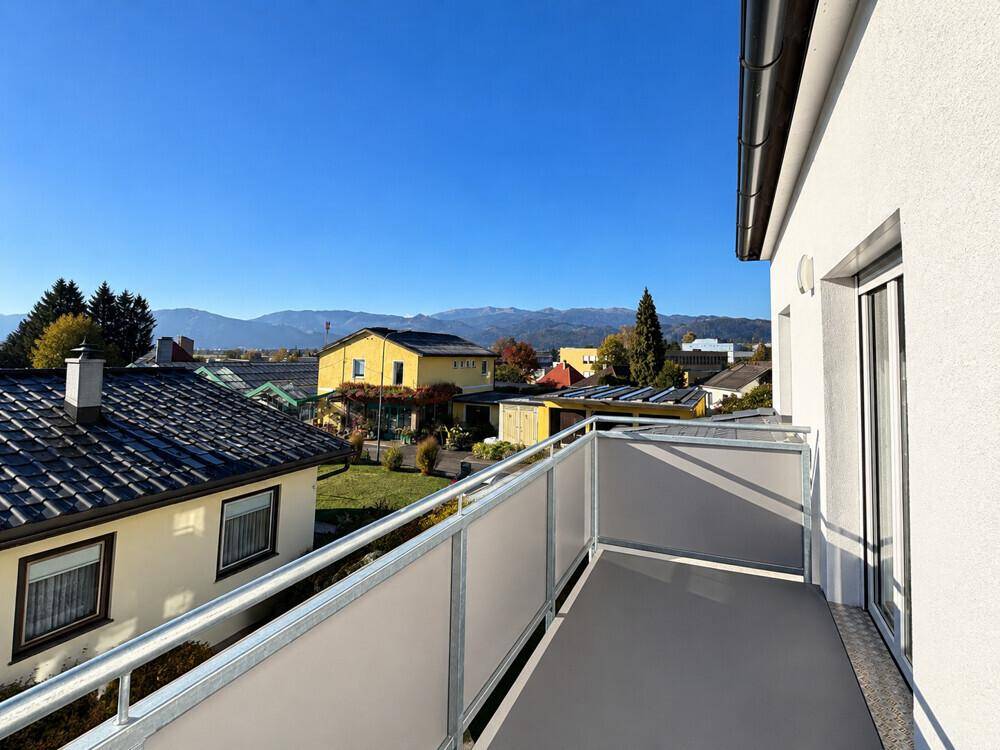 Sonniger Balkonblick auf Berge und Vorstadt