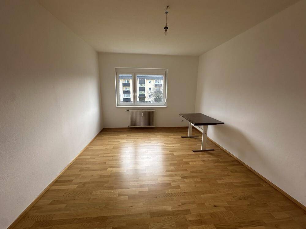 Geräumiges, helles Zimmer mit Laminatboden und einem Fenster, das viel Licht hereinlässt.