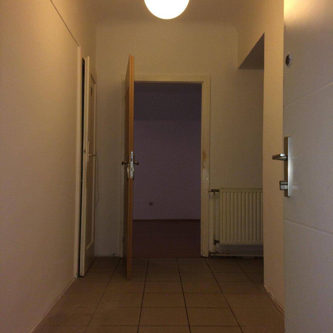 Heller Flur mit Fliesenboden und Zugang zu weiteren Räumen der Wohnung.