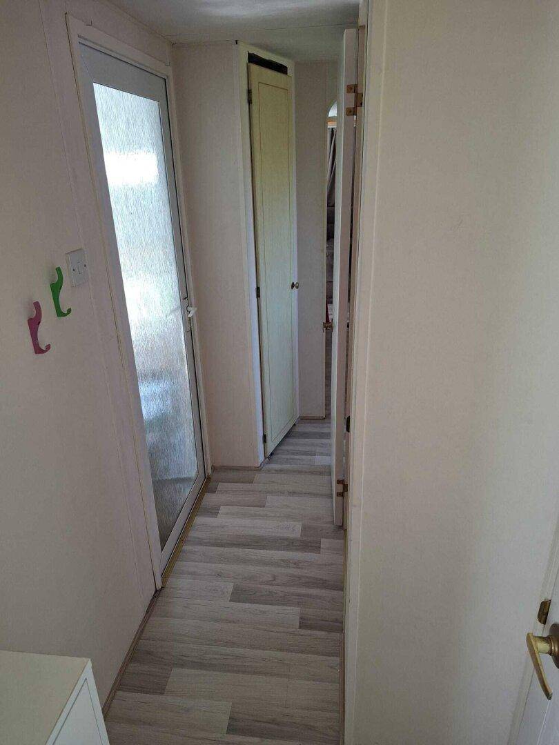 Heller Flur mit Laminatboden und Zugang zu verschiedenen Räumen.