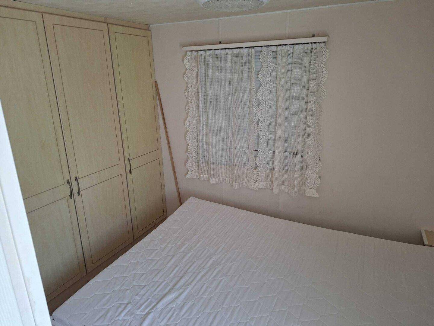 Schlafzimmer mit Doppelbett und praktischen Einbauschränken.
