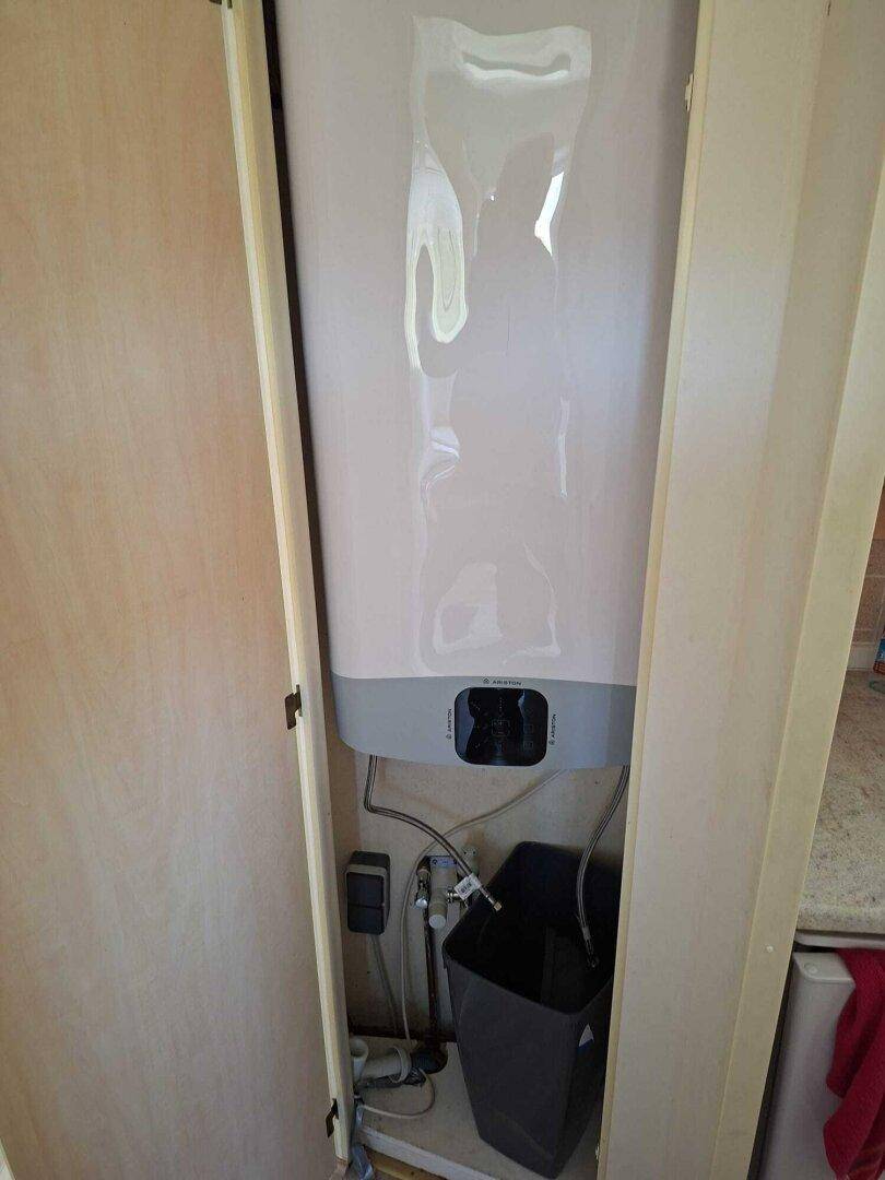 Hauswirtschaftsraum mit Warmwasserbereiter und Anschlüssen.